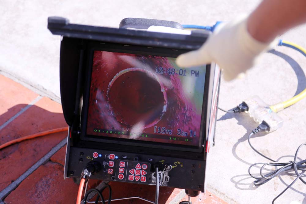 Technician looking at a video monitor of a sewer camera inspection