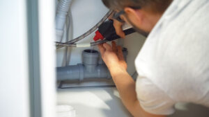 Total Drain Solutions technician cleaning a Sovent system