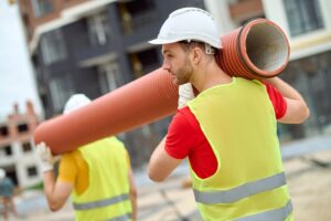 drain technicians carrying pipe lining equipment / drain technicians carrying pipe